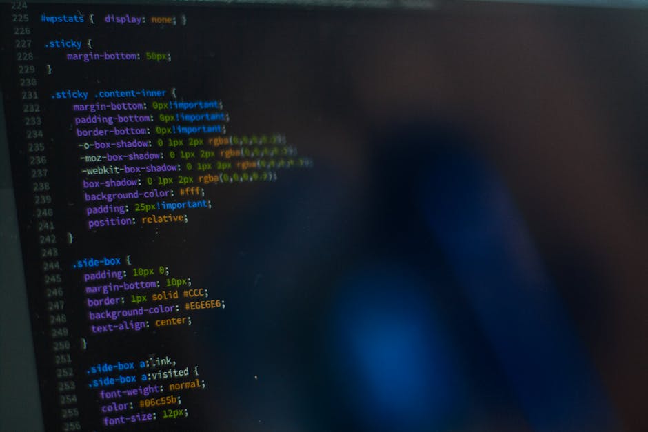 A close-up photograph of a computer screen displaying lines of CSS code with color-coded syntax, including selectors, properties, and values such as 'margin-bottom', 'padding', 'border', and 'backgrou